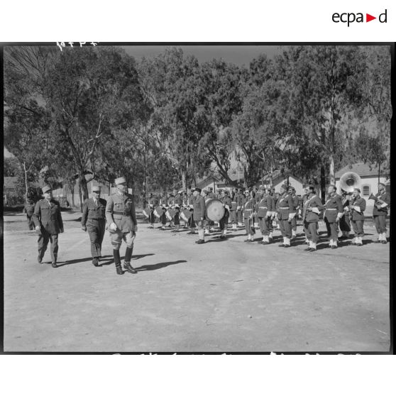 Des autorités militaires passent en revue des troupes de l'armée de terre.