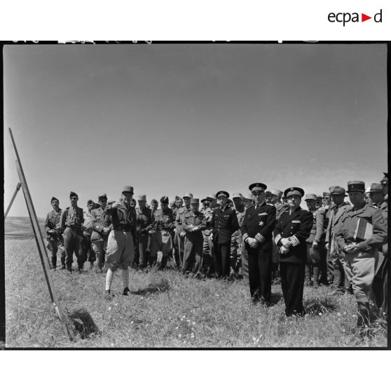 Le général de brigade Jean Breuillac échange avec des autorités militaires devant une carte de manoeuvres, sur un camp militaire.