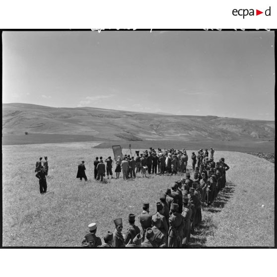 Vue en plongée d'un groupe d'autorités militaires et de troupes de tirailleurs algériens réunis sur un camp militaire pour faire des exercices.