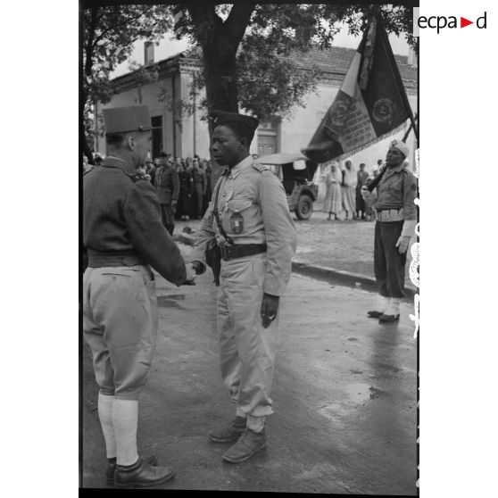 Défilés d'unités militaires et cérémonie de remise de décorations, sous la direction du général de brigade Jean Breuillac, devant la mairie de Aïn Bessem.