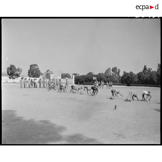 Des soldats font des mouvements de gymnastique, sous le regard du général de corps d'armée Henry Martin, accompagné d'autorités civiles et militaires.