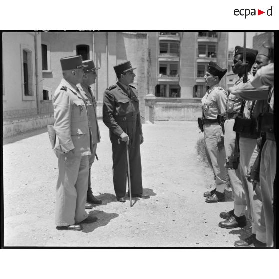 Le général Jean Lattre de Tassigny s'entretient avec une personnalité militaire, accompagné du général de corps d'armée Henry Martin et du général de brigade Jean Breuillac.