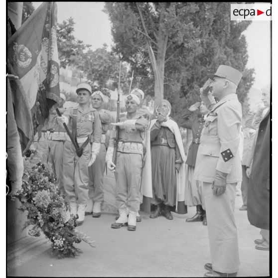 Le général de corps d'armée Henry Martin salue le drapeau de la 87e division d'infanterie alpine (DIA), devant le monument aux morts d'Alger.