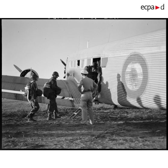 Des parachutistes montent à bord d'un avion de transport.