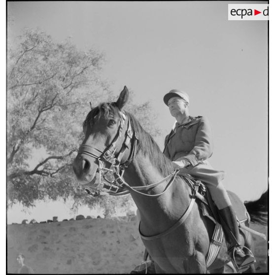Portrait en contre-plongée d'une autorité militaire à cheval.