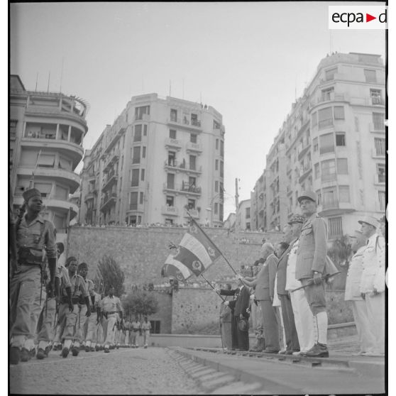 Défilé du 9e bataillon de zouaves (BZ), sous le regard du gouverneur général de l'Algérie, Yves Chataigneau, du général de corps d'armée Henry Martin, du général de brigade Jean Breuillac, d'autorités civiles et militaies, sur la place du forum d'Alger.