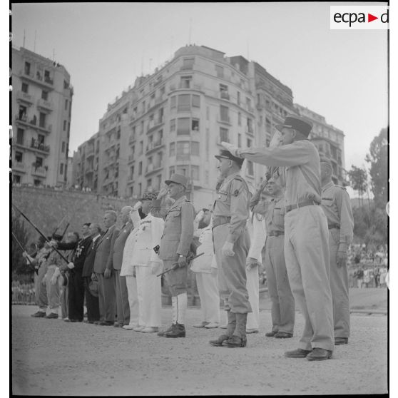 Yves Chataigneau, gouverneur général de l'Algérie, Henry Martin, général de corps d'armée et Jean Breuillac, général de brigade, assistent à la cérémonie militaire à l'occasion du retour à Alger du 9e bataillon de zouaves (BZ), sur la place du forum d'Alger.