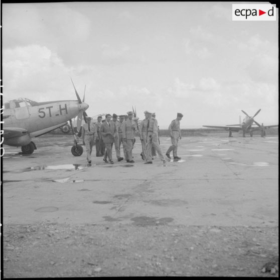 Visite du ministre des Armées, Edmond Michelet, sur une base aérienne, accompagné d'autorités militaires. A gauche, un P-63 Kingcobra du GC 1/5 Vendée.