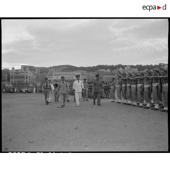 Le général de corps d'armée Henry Martin passe en revue des unités militaires, accompagné d'autorités civiles et militaires.