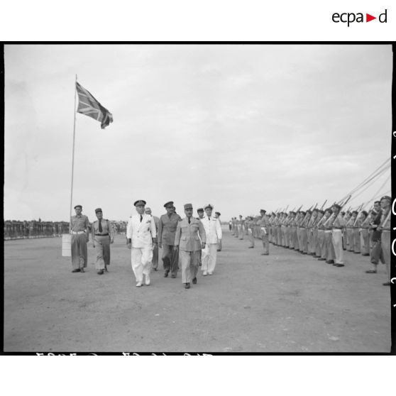 Le général de corps d'armée Henry Martin passe en revue des troupes, accompagné d'autorités militaires.