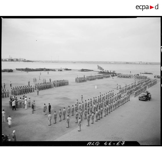 Plan d'ensemble en plongée de la cérémonie à l'occasion du départ d'Afrique française du nord (AFN) des derniers éléments de l'armée britannique sur le port d'Alger.