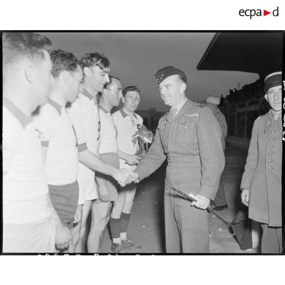 Général de brigade félicitant une équipe de basket-ball militaire lors d'une finale dans le stade municipal d'Alger.