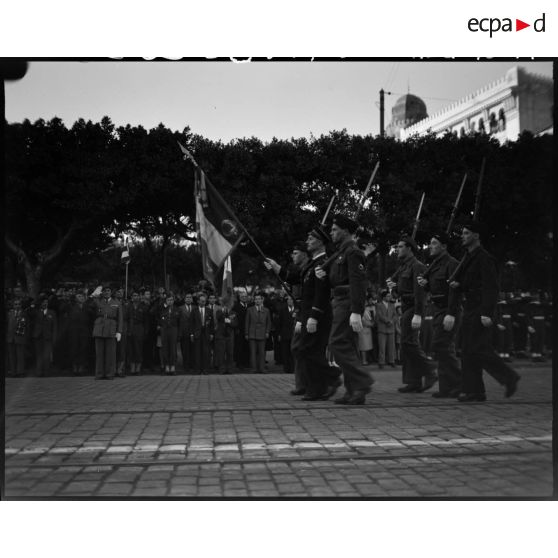 Garde au drapeau d'une unité militaire, sous le regard d'autorités civiles et militaires.