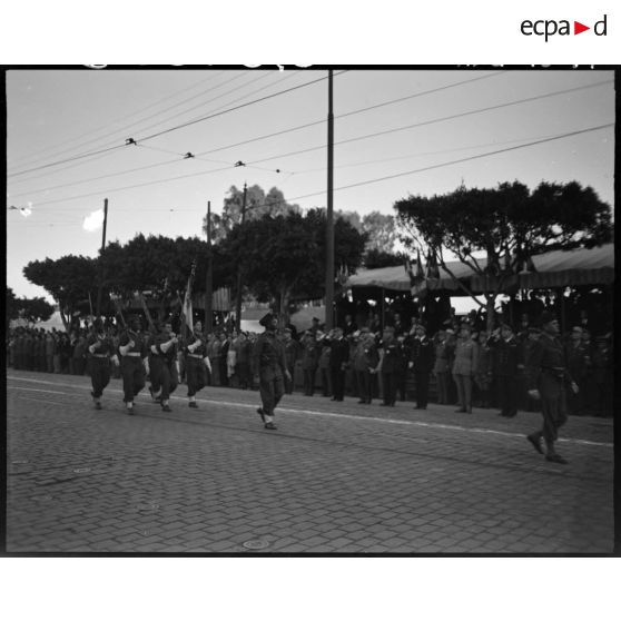 Garde au drapeau d'une unité militaire, sous le regard d'autorités civiles et militaires.