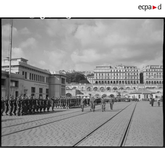 Le général de corps d'armée Henry Martin, accompagné d'autorités militaires, passe en revue des troupes, sur le port d'Alger, à l'occasion de la cérémonie organisée pour son départ.
