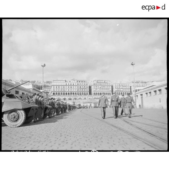 Le général de corps d'armée Henry Martin passe en revue une unité militaire motorisée, sur le port d'Alger, à l'occasion de la cérémonie organisée pour son départ.
