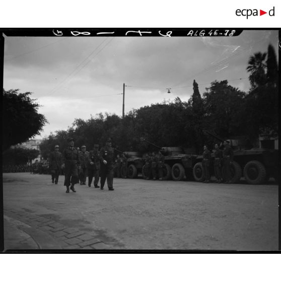 Le général Duché passe en revue une unité militaire motorisée, dans les rues d'Alger.