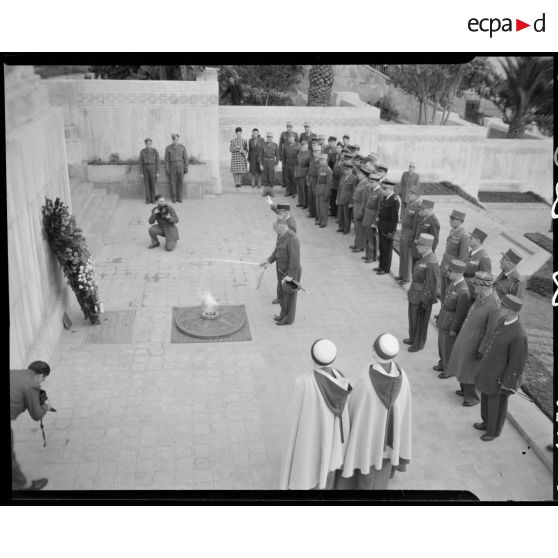Le général Duché ravive la flamme du monument aux morts d'Alger, sous le regard d'autorités militaires.