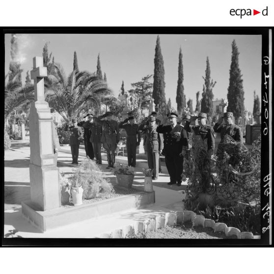 Le général de corps d'armée Henry Martin et des autorités militaires saluent une tombe, dans un cimetière de Sidi-Bel-Abbès.