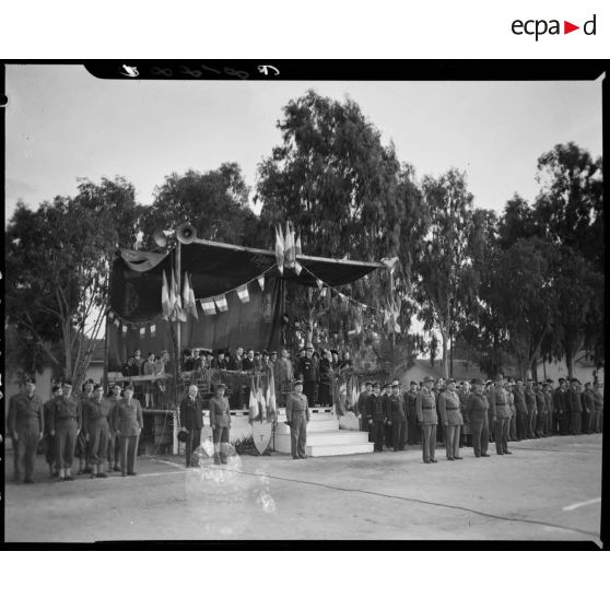 Plan d'ensemble de la tribune rassemblant des autorités civiles et militaires qui assistent à la cérémonie de remise de drapeau au 45e régiment de transmissions (RTrs) par le général Merlin.