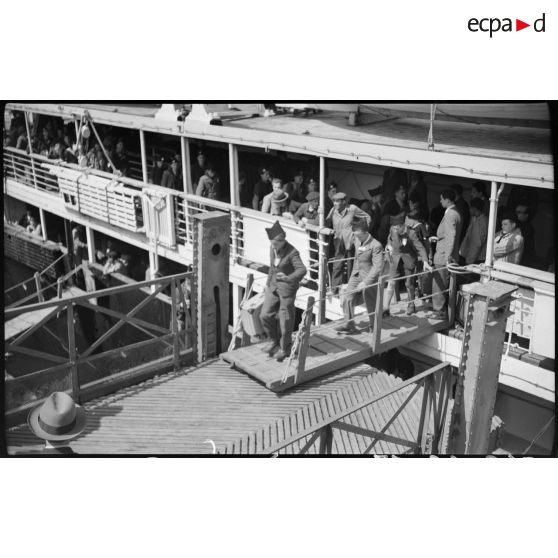 Des jeunes gens originaires de Saint-Etienne débarquent de leur bateau, au port d'Alger.