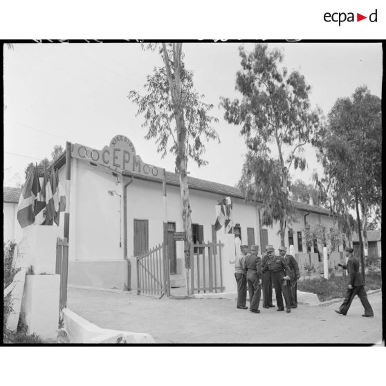 Le général de corps d'armée Henry Martin s'entretient avec des autorités militaires devant un centre de formation d'aides moniteurs d'éducation physique militaire (EPM).
