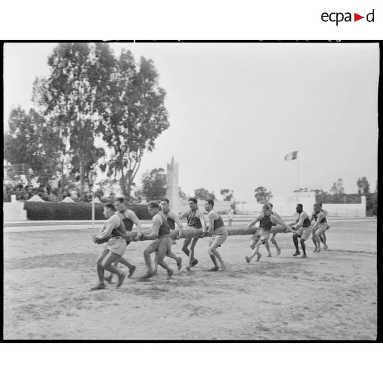 Des aides moniteurs d'éducation physique militaire (EPM) effectuent un exercice d'entrainement avec un tronc d'arbre.