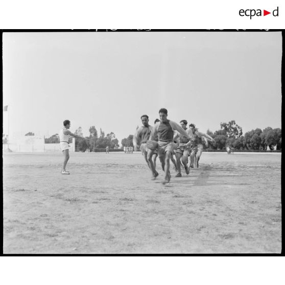 Des aides moniteurs d'éducation physique militaire (EPM) effectuent un exercice d'entrainement avec un tronc d'arbre.