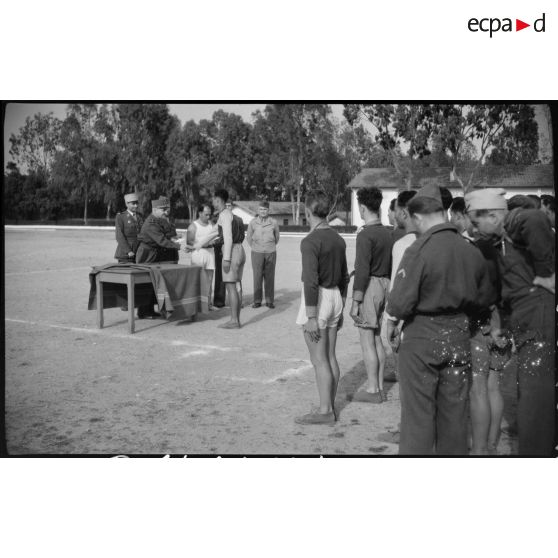 Le général de corps d'armée Henry Martin félicite un aide moniteur de la 1ère promotion des aides moniteurs d'éducation physique militaire (EPM).