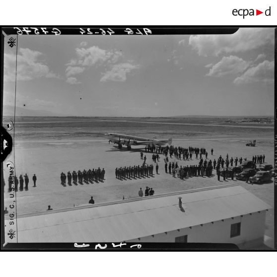 Plan en plongée de l'arrivée de Charles Tillon, ministre de l'armement, sur un aérodrome à Alger.