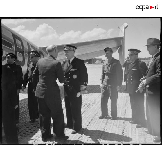 Charles Tillon, ministre de l'armement, est reçu par une autorité militaire, sur un aérodrome, à Alger.