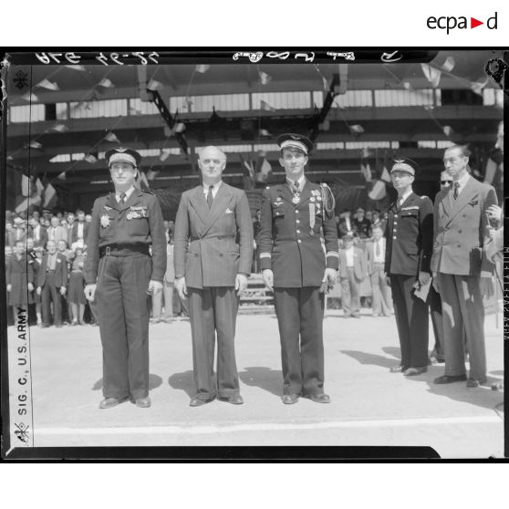 Portrait en pied de Charles Tillon, ministre de l'armement, et de deux autorités militaires de l'armée de l'Air auxquelles il a remis des décorations.