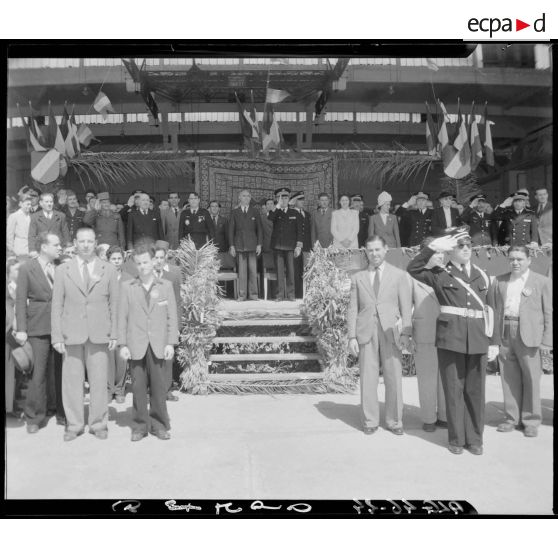 Plan d'ensemble de la tribune depuis laquelle Charles Tillon, ministre de l'armement, accompagné d'autorités civiles et militaires, participe à une cérémonie militaire organisée par l'armée de l'Air.