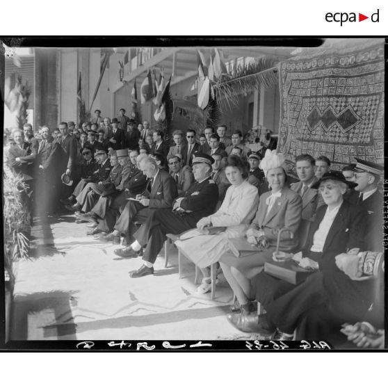 Plan d'ensemble de la tribune depuis laquelle Charles Tillon, ministre de l'armement, accompagné d'autorités civiles et militaires, participe à une cérémonie militaire organisée par l'armée de l'Air.