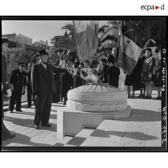 Rallumage de la flamme par une personnalité civile devant le monument aux morts d'Alger.
