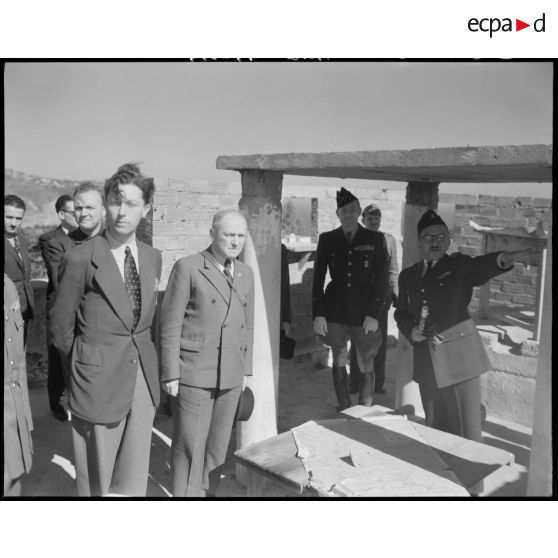 Une autorité militaire, assistée du général Schlesser, échange autour d'une carte, avec des personnalités civiles.