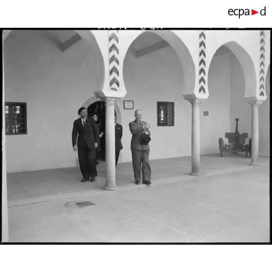 Des personnalités civiles sortent d'une structure militaire.