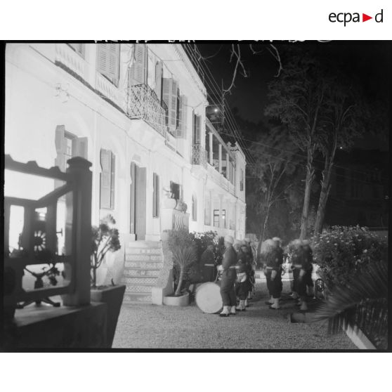 Plan d'une musique militaire devant un batiment.