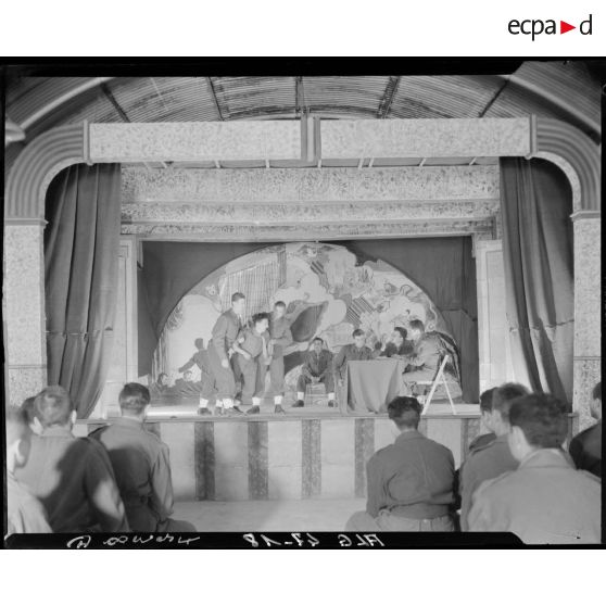 Des soldats se produisent sur une scène de théâtre.