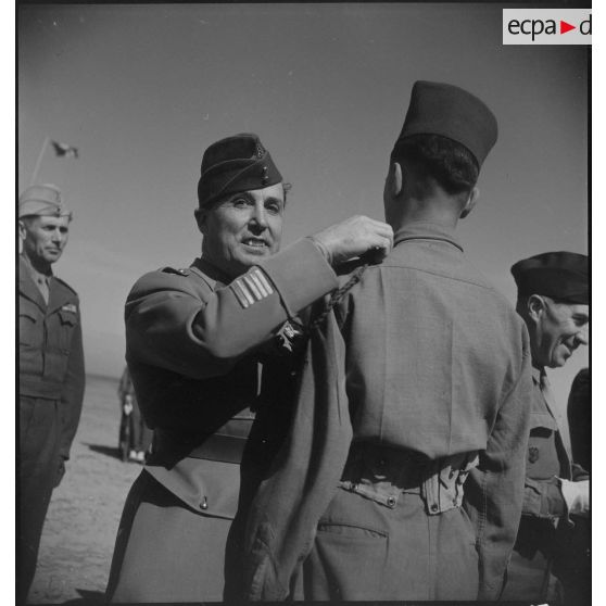 Une autorité militaire remet une décoration à une jeune recrue du 8e bataillon de zouaves (BZ).