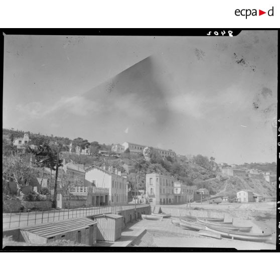 Plan en contre-plongée de l'établissement du service de santé de la 10e région militaire (RM), à l'extérieur de l'enceinte, depuis la plage, à Bab el Oued.