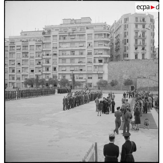 Plan d'ensemble de la cérémonie militaire donnée à l'occasion de remise de décorations aux policiers résistants, sur la place du forum d'Alger.