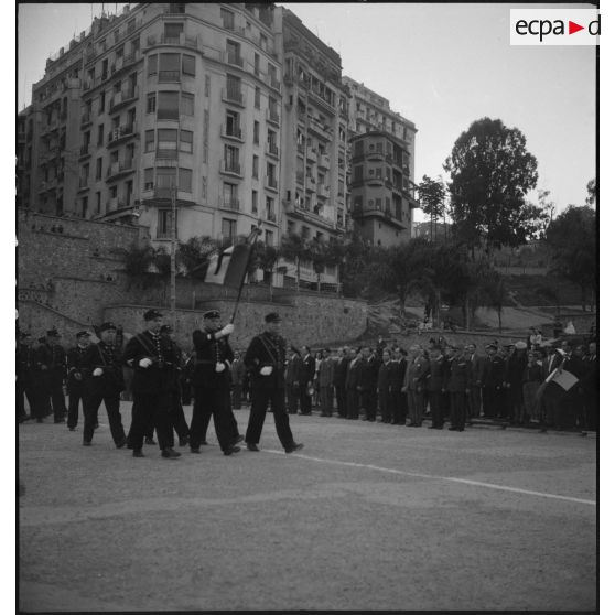 Défilé d'une unité militaire, sous le regard d'autorités civiles et militaires, sur la place du forum d'Alger.