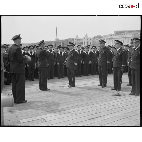 Cérémonie de remise de la croix de guerre à la compagnie de débarquement du croiseur Suffren, à quai, dans le port d'Alger.