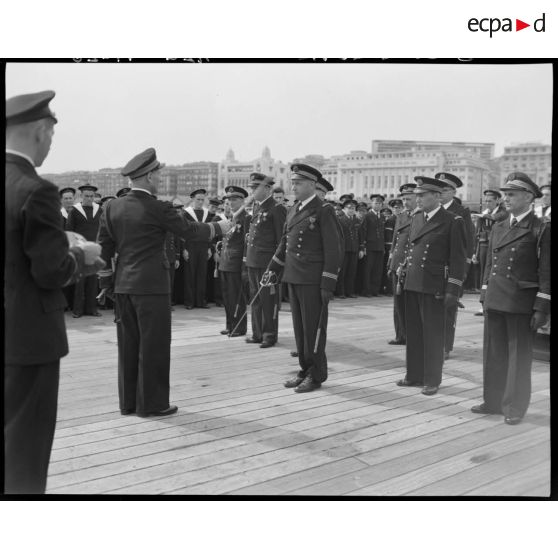 Cérémonie de remise de la croix de guerre à la compagnie de débarquement du croiseur Suffren, à quai, dans le port d'Alger.