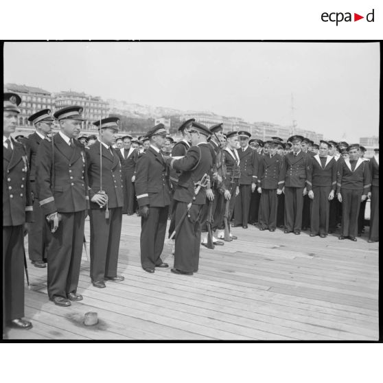 Cérémonie de remise de la croix de guerre à la compagnie de débarquement du croiseur Suffren, à quai, dans le port d'Alger.
