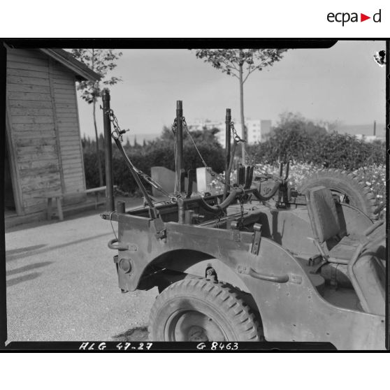 Détail d'un système de fixation pour deux brancards à l'arrière d'une voiture Jeep, afin de permettre sa transformation en transport sanitaire.