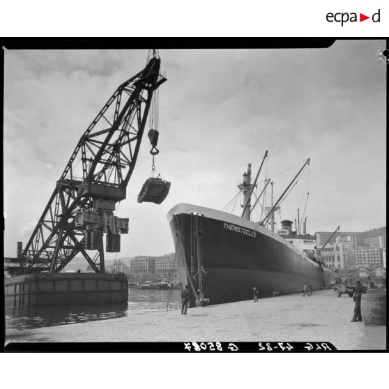 Débarquement d'un véhicule militaire à l'aide d'une grue portuaire.