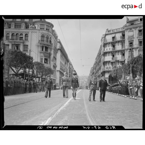 Yves Chataigneau, gouverneur général de l'Algérie et le général Schlesser passent en revue des unités militaires, accompagnés d'autorités militaires.