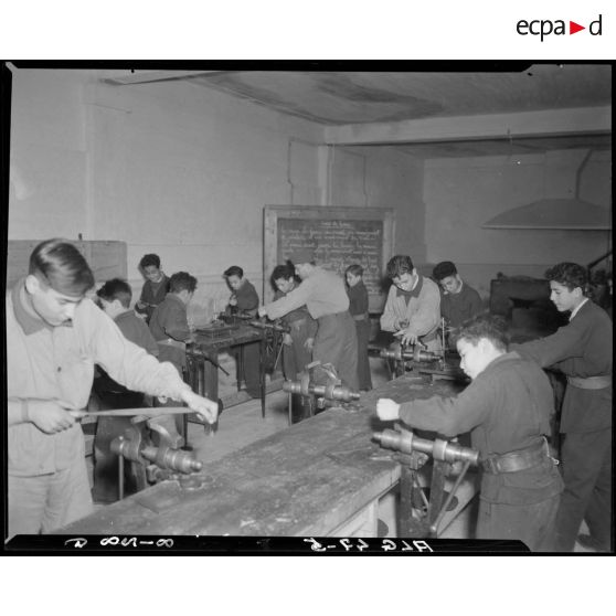 Des élèves travaillent dans un atelier, autour d'établis.